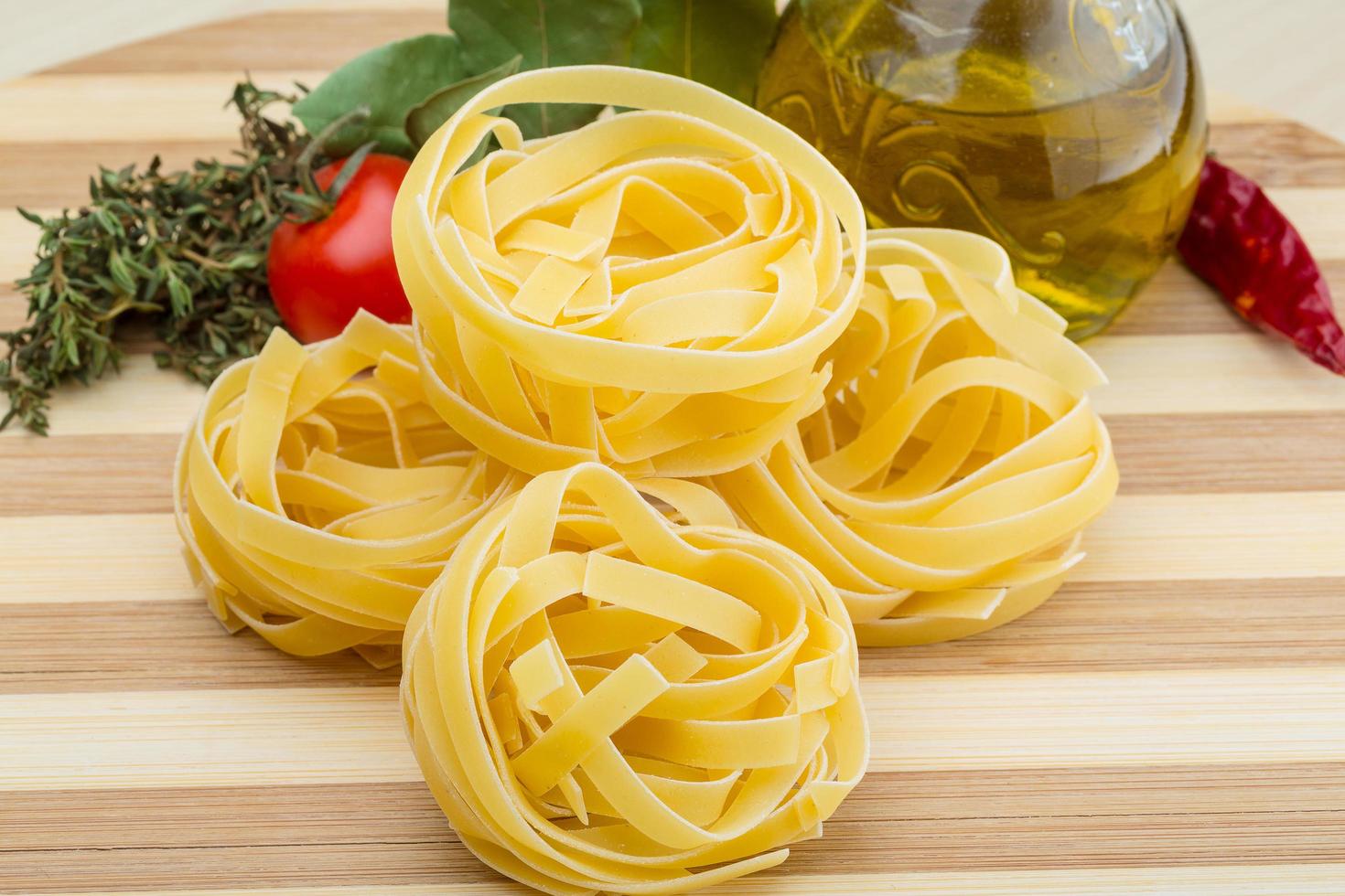 fettuccine cru em fundo de madeira foto