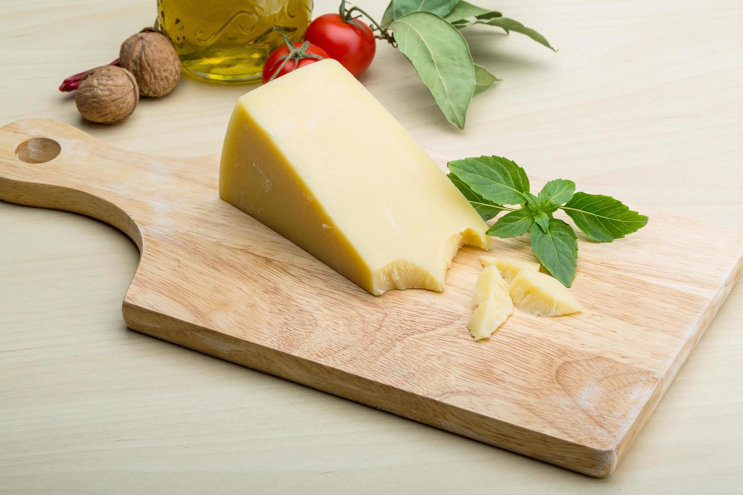 queijo parmesão na tábua de madeira e fundo de madeira foto