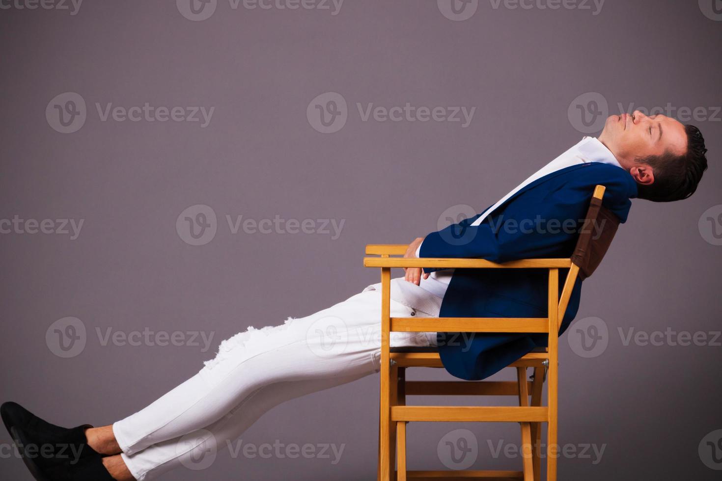 empresário cansado relaxando em uma cadeira com os olhos fechados. foto