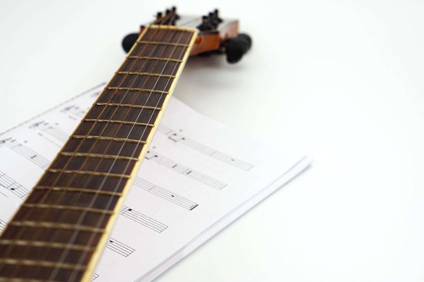 pescoço de violão com notas musicais contra fundo branco. conceito de amor e música. foto