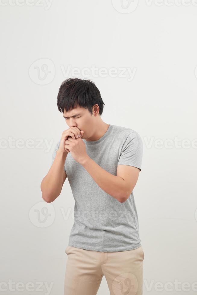homem bonito tossindo em seu punho, isolado em um fundo branco foto