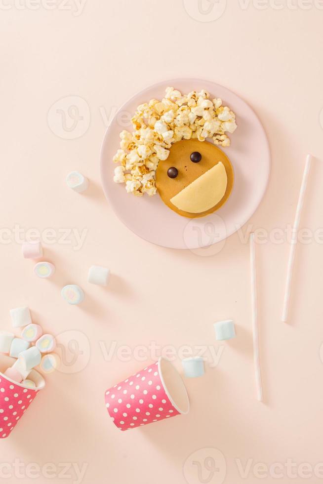 panquecas de bebê no café da manhã. ideia criativa para a sobremesa infantil deliciosas panquecas em forma de carinha feliz com o cabelo fazendo pipoca foto