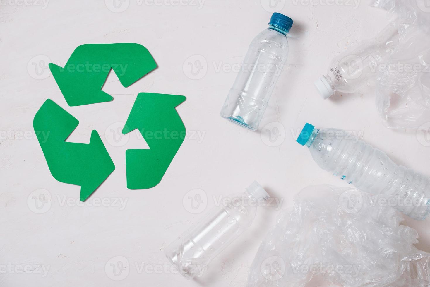 símbolo ecológico de reciclagem de resíduos com depósito de lixo na vista superior do fundo da mesa de pedra foto