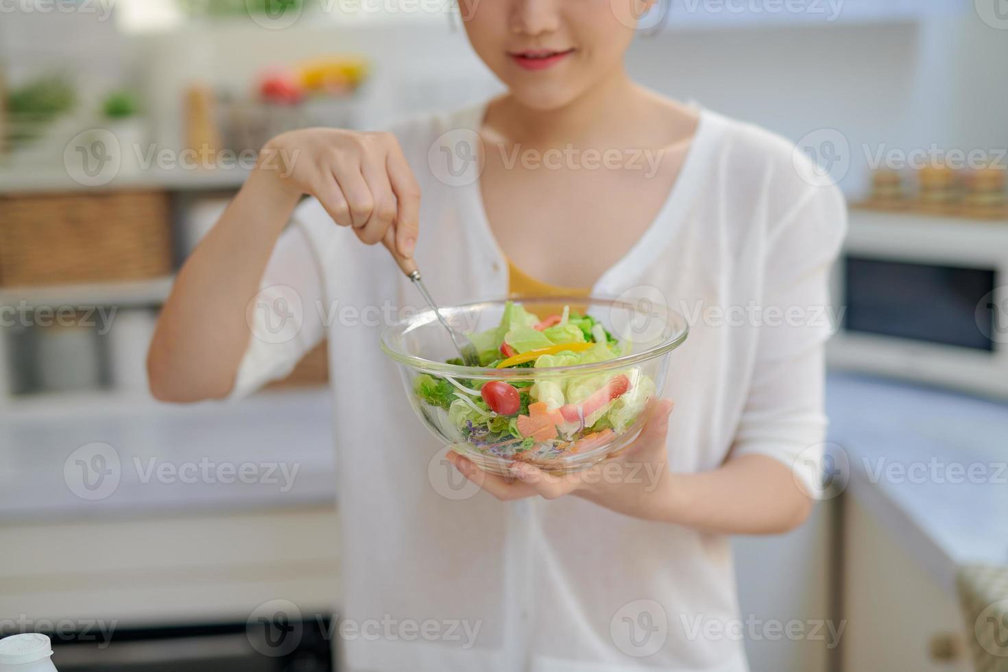 linda jovem com um prato de salada fresca de vitaminas de legumes foto