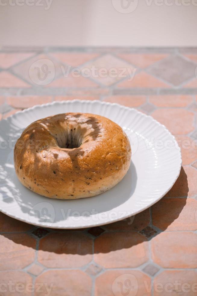 rosquinha na chapa branca no fundo da mesa sob luz solar natural foto