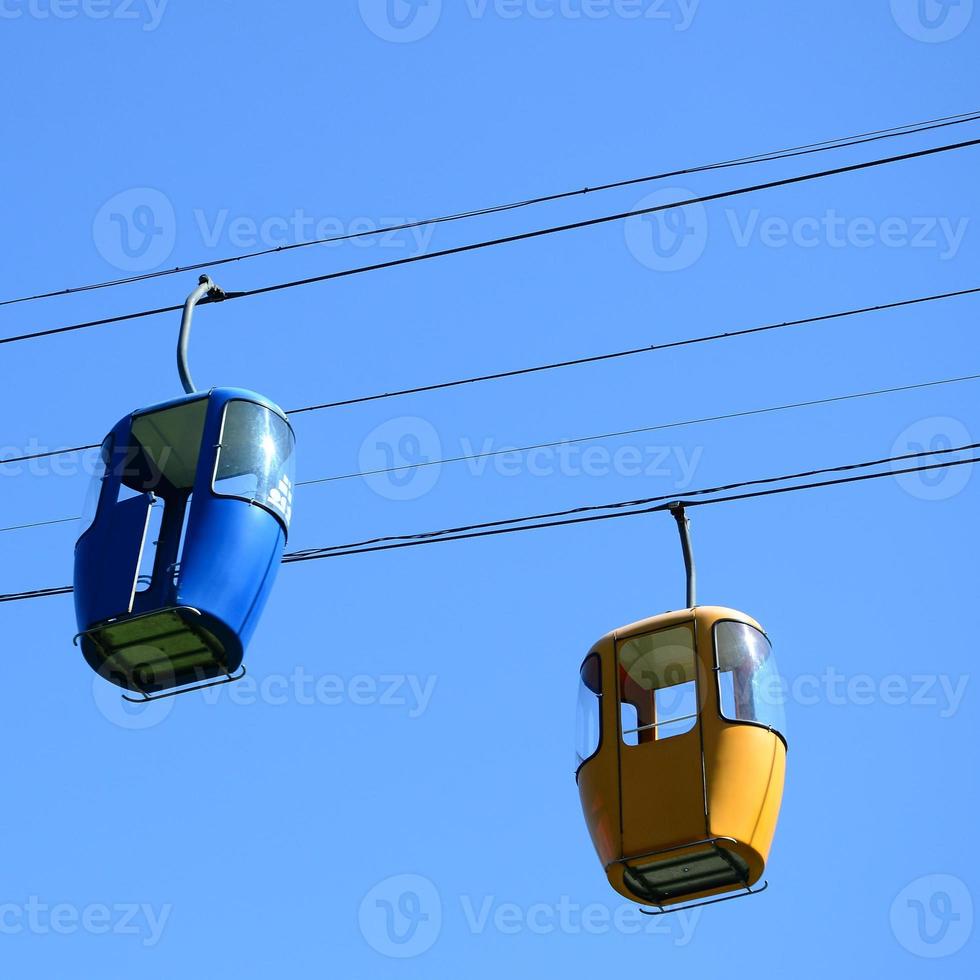 cabines de teleférico de passageiros azul e amarelo no céu claro foto