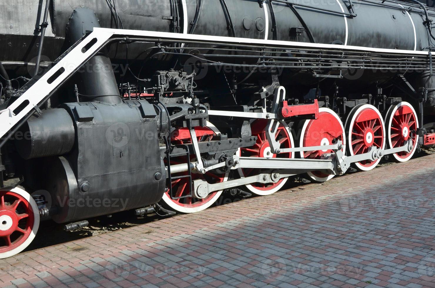 rodas da velha locomotiva a vapor preta dos tempos soviéticos. o lado da locomotiva com elementos da tecnologia rotativa de trens antigos foto