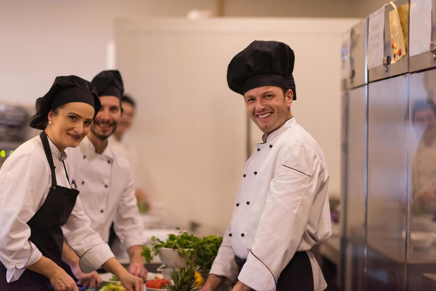 cozinheiros e chefs de equipe preparando a refeição foto