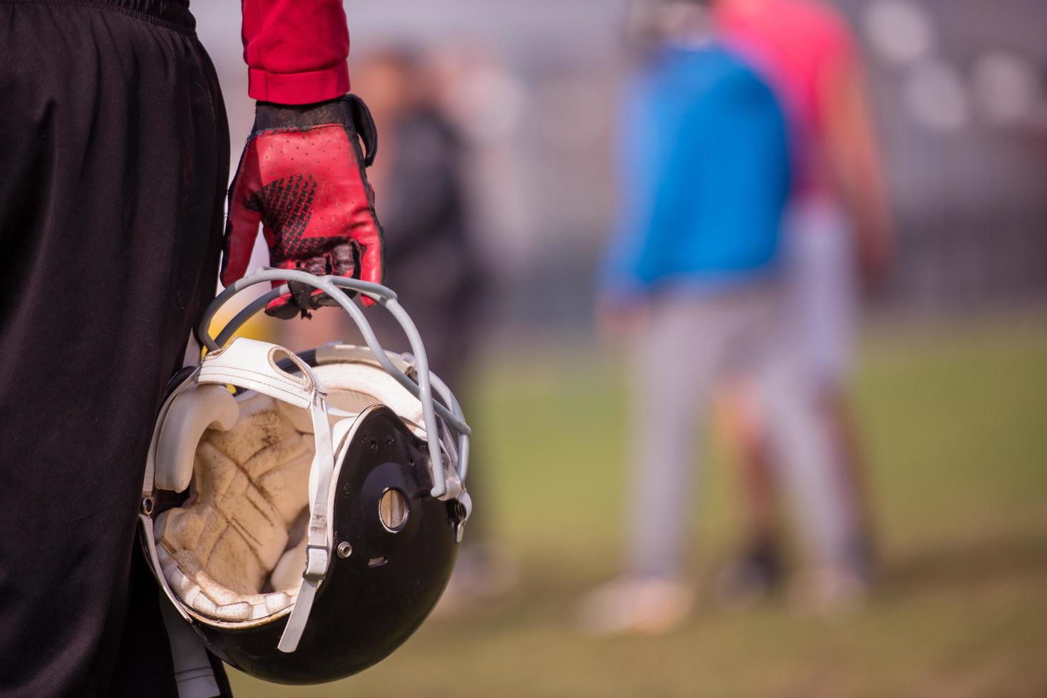 jogador de futebol americano segurando capacete foto