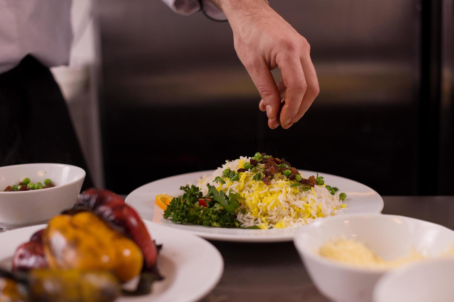 mãos de chef servindo risoto de legumes foto