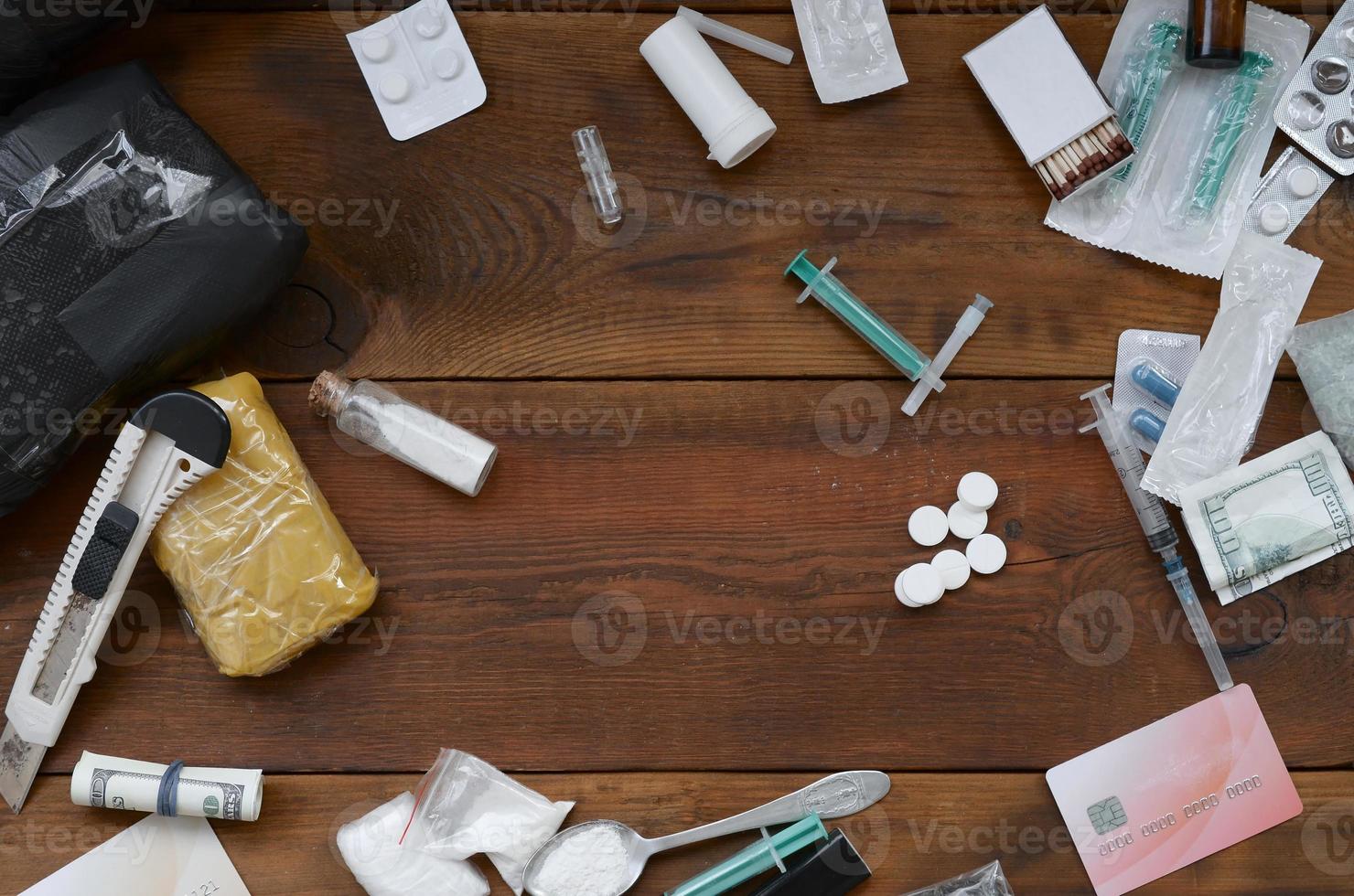 pacotes de coisas de drogas em pó, notas de dólar e seringa médica de pílulas de drogas sintéticas foto