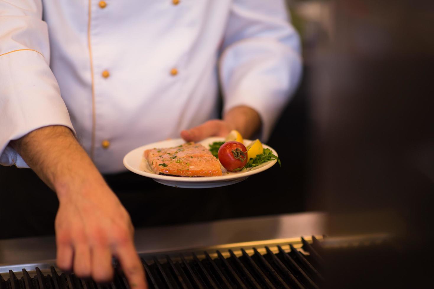 mãos de chef cozinhando peixe salmão grelhado foto