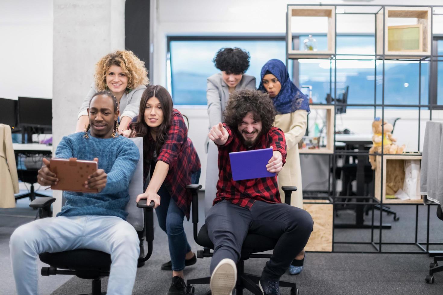 equipe de negócios multiétnica competindo em cadeiras de escritório foto