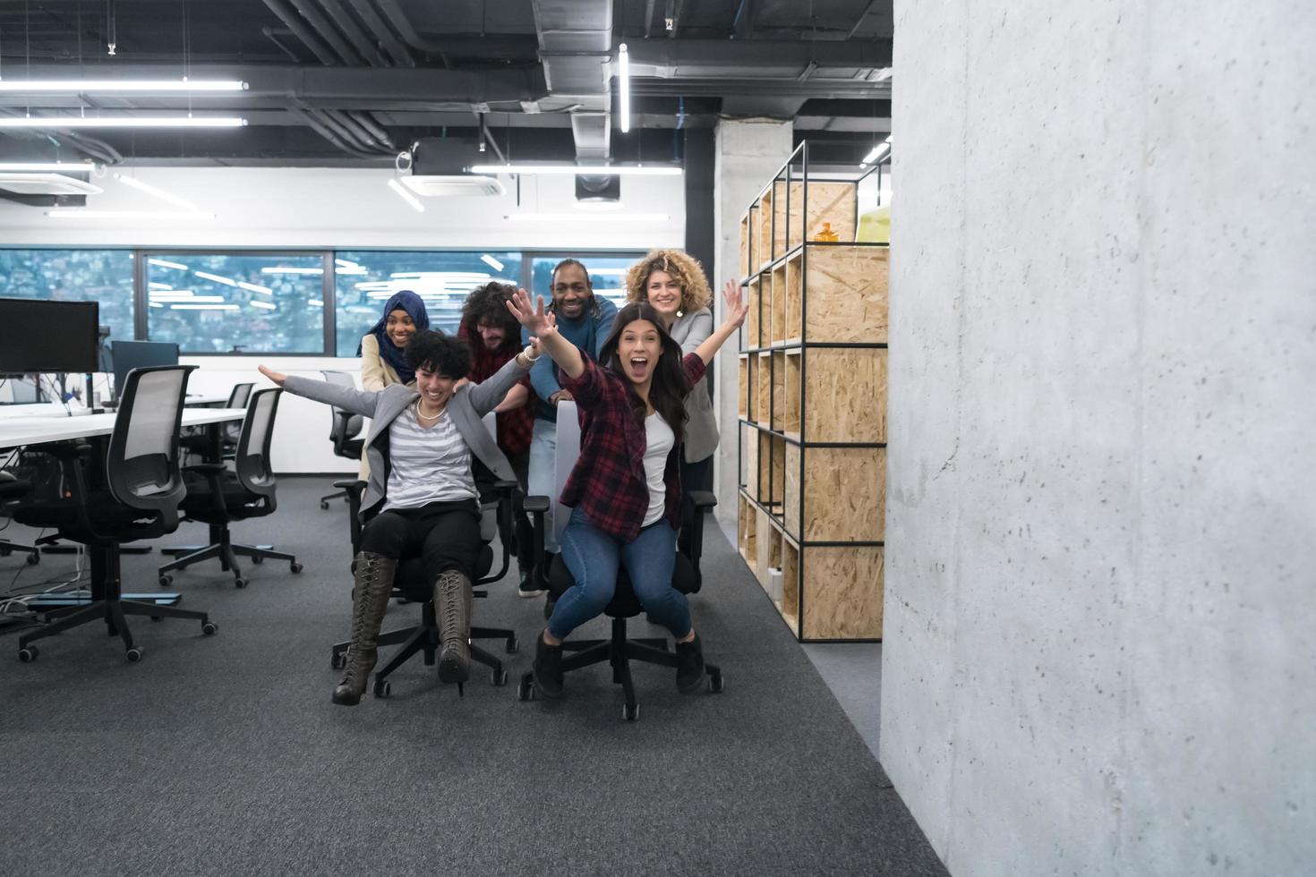 equipe de negócios multiétnica competindo em cadeiras de escritório foto