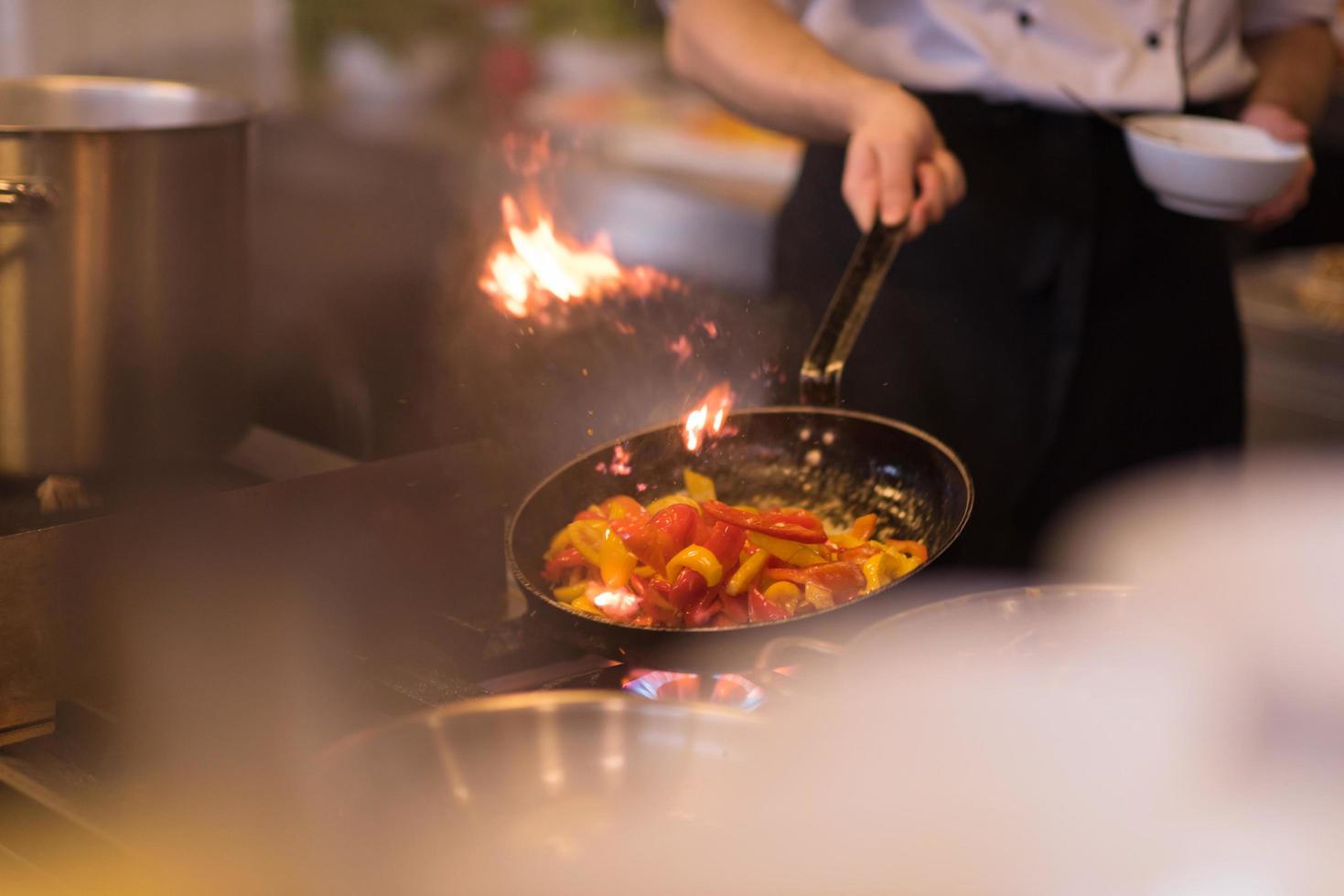 chef fazendo flambe na comida foto