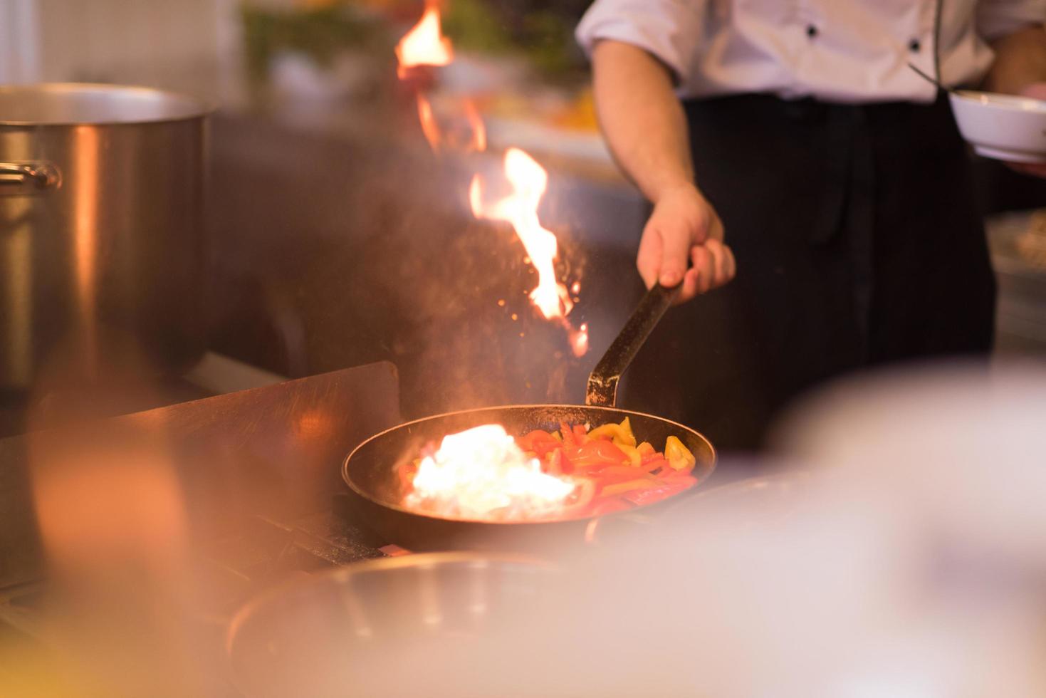 chef fazendo flambe na comida foto