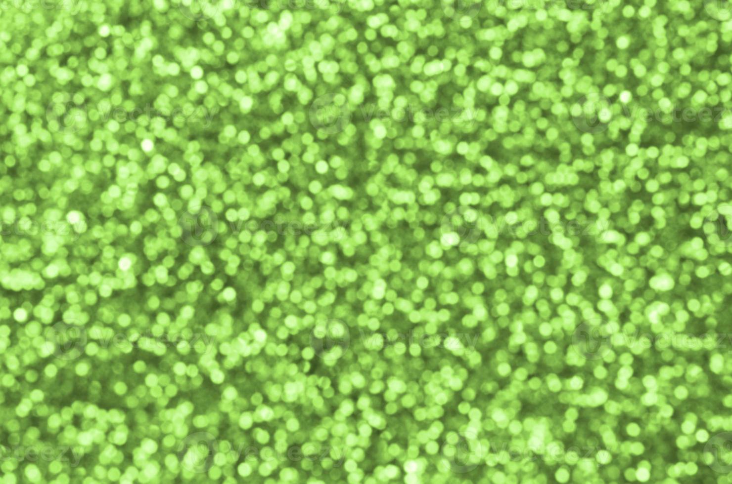 lantejoulas decorativas verde limão turva. imagem de fundo com luzes de bokeh brilhantes de pequenos elementos foto