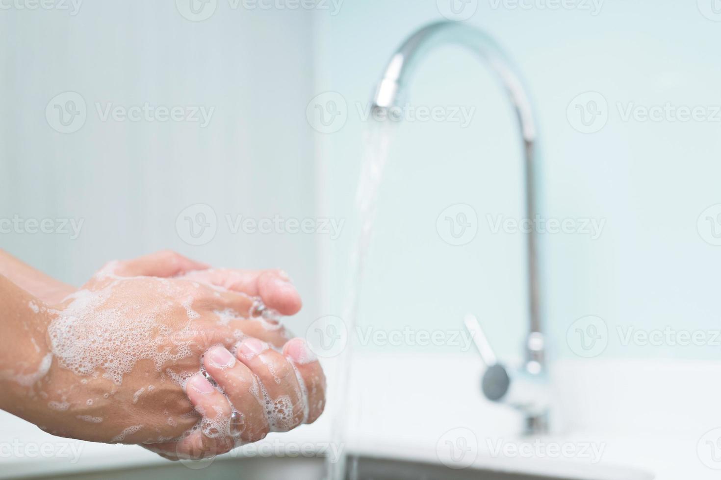 mãos de limpeza. lavar a mão sob a torneira da pia da cozinha com água paga sujeira, germes de limpeza, bactérias e vírus para higiene. conceito de cuidados de saúde. foto
