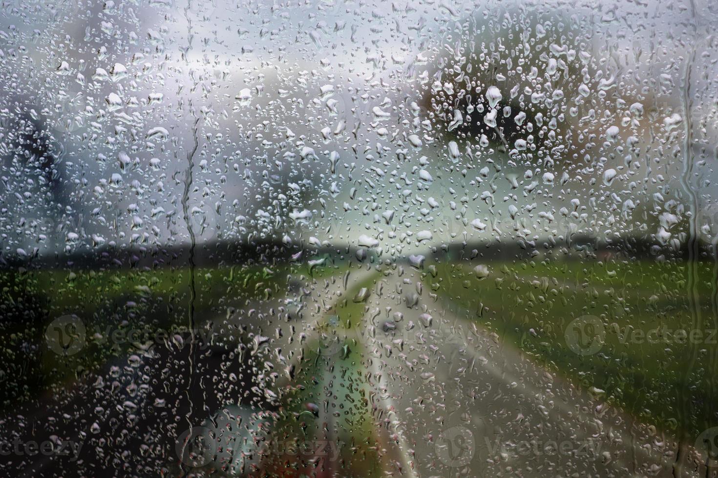 janela chuvosa, pingos de chuva no vidro no fundo da rodovia. caminho seguro para casa. foto