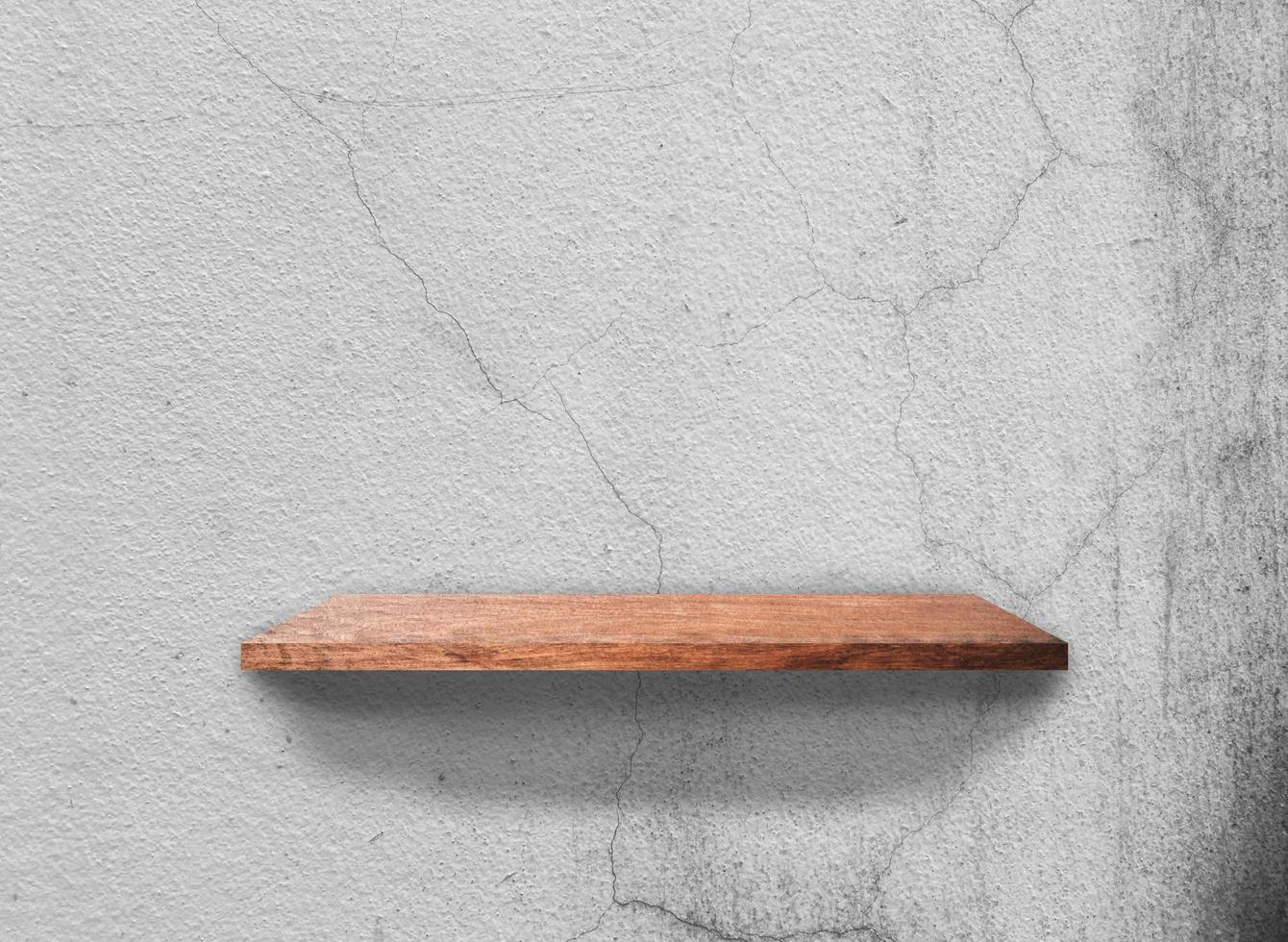 prateleiras de madeira vintage em fundo de textura de parede de concreto com traçado de recorte. em branco para design foto