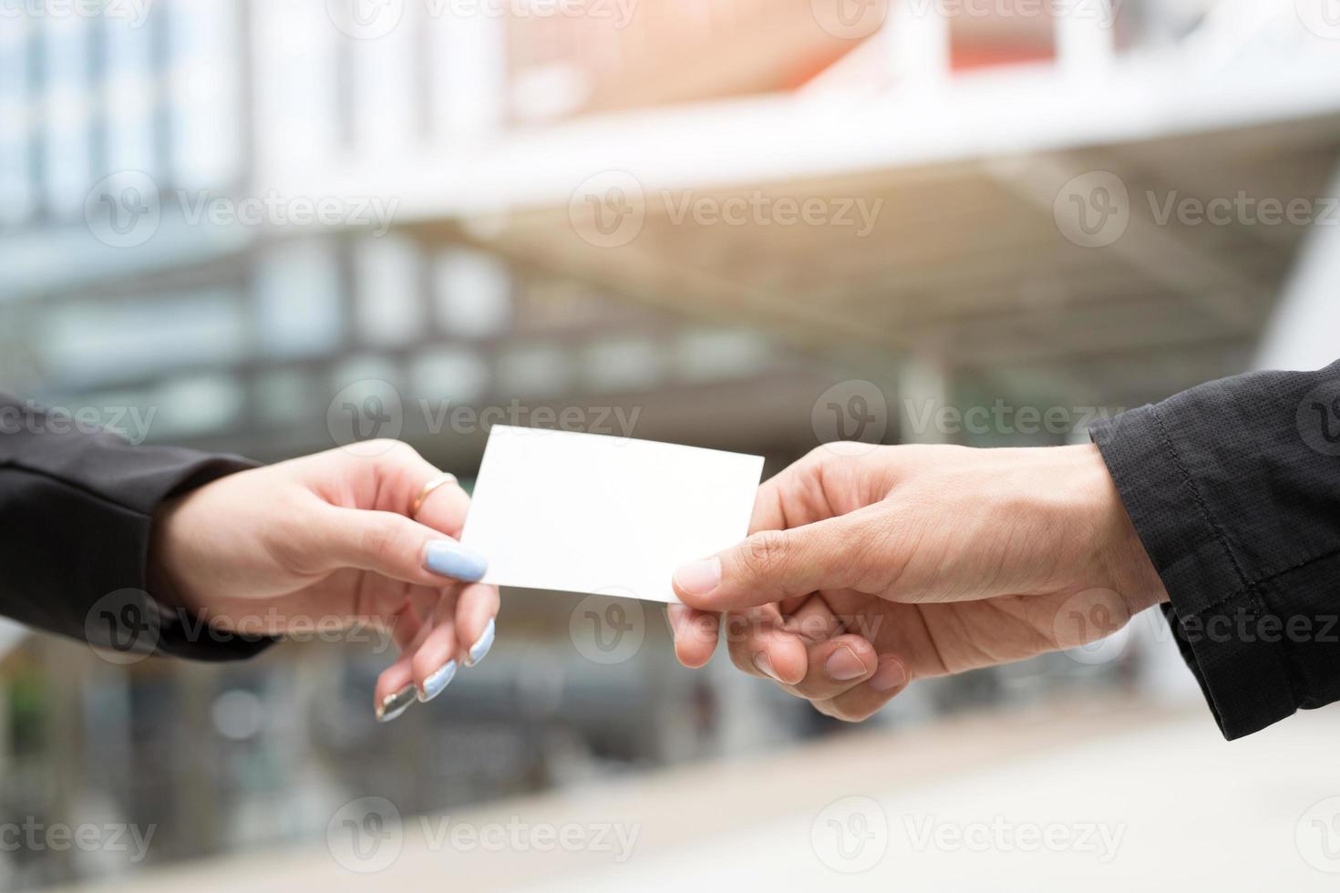 pessoas homem mão segurar cartões de visita mostram maquete de cartão branco em branco. ou frente de exibição de cartão de crédito em papelão. conceito de marca de negócios. foto
