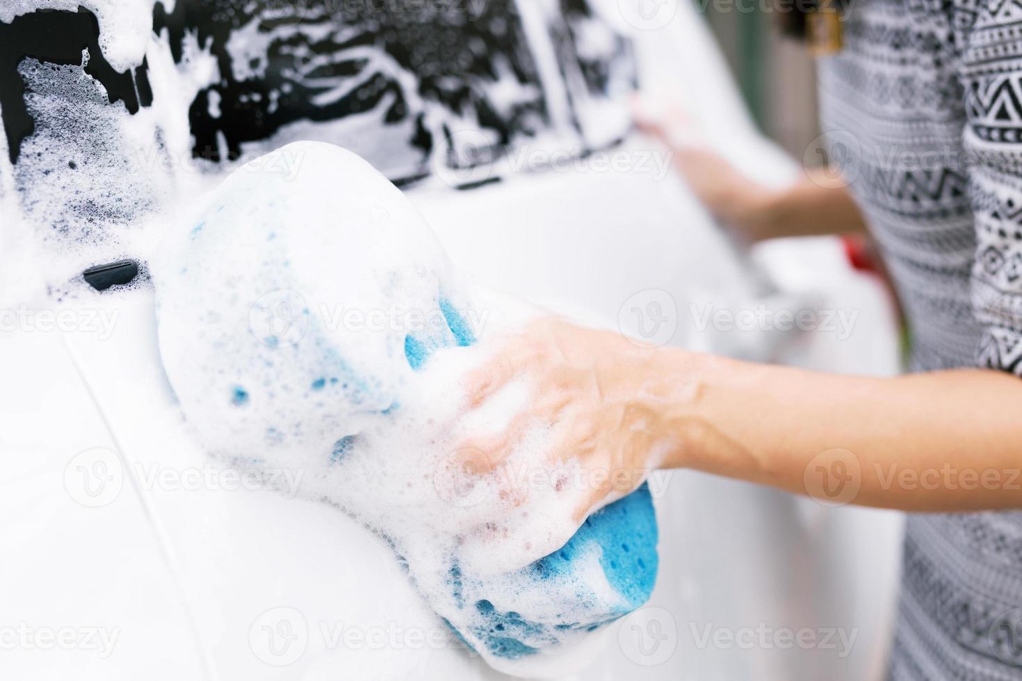 as pessoas seguram o carro de lavagem de esponja azul. foto