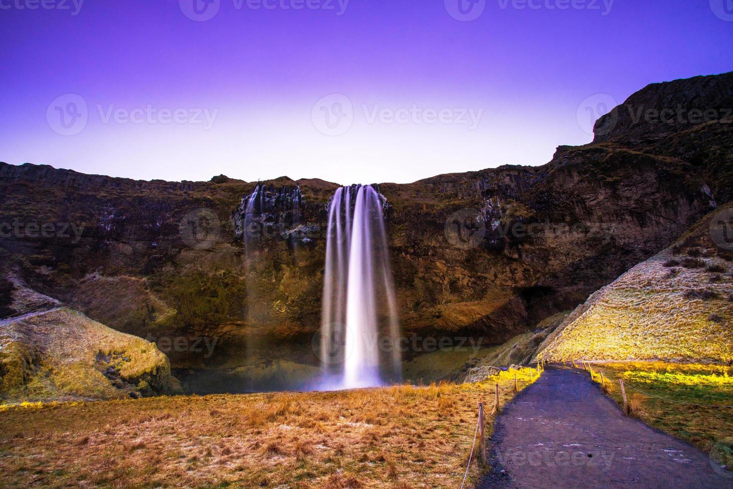 seljalandsfoss, uma cachoeira com uma pequena caverna atrás dela na região sul da islândia, faz parte do rio seljalands que tem sua origem na geleira do vulcão eyjafjallajokull foto