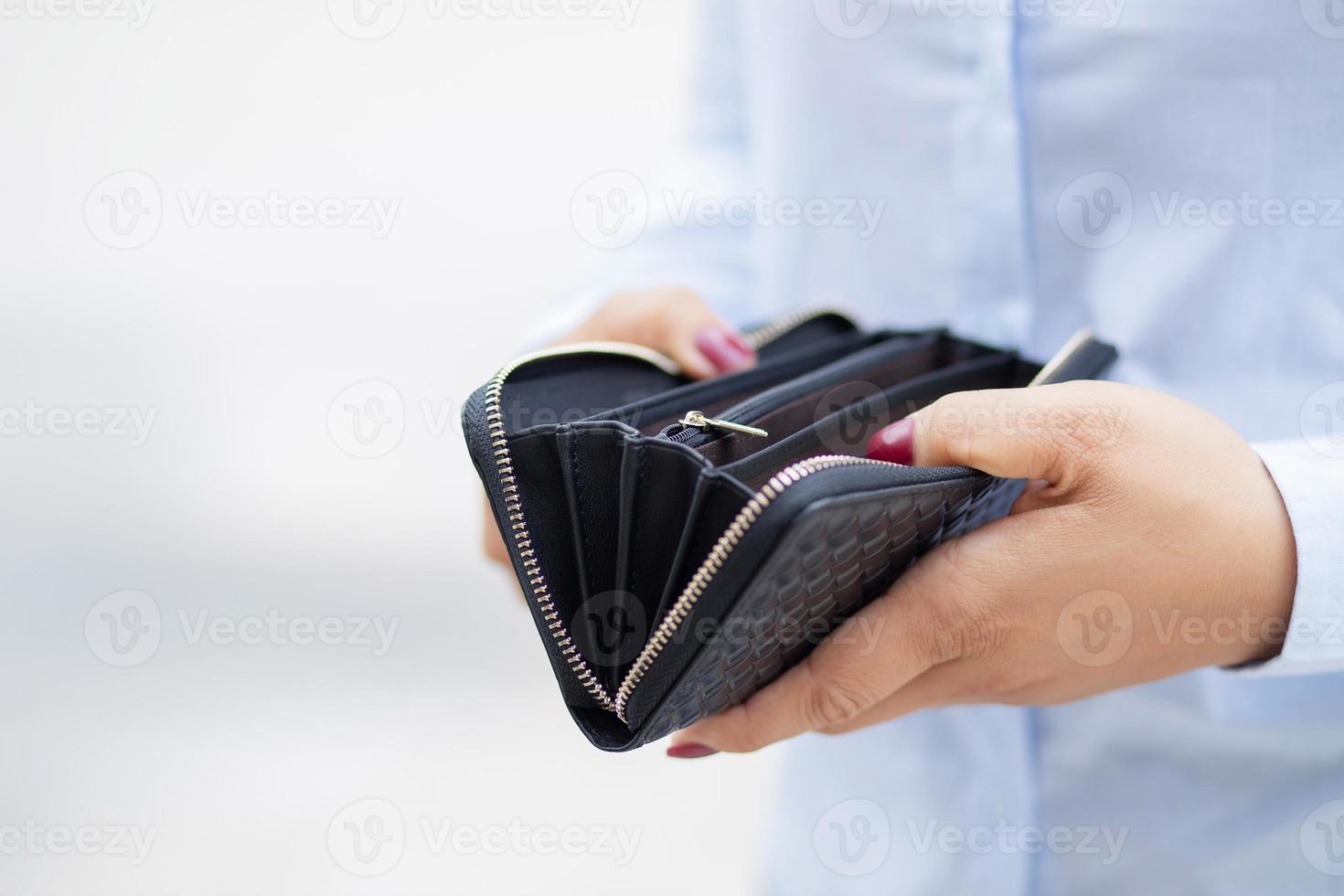 mulher segurando uma carteira de moda, ela está fazendo compras em uma loja de departamentos. foto