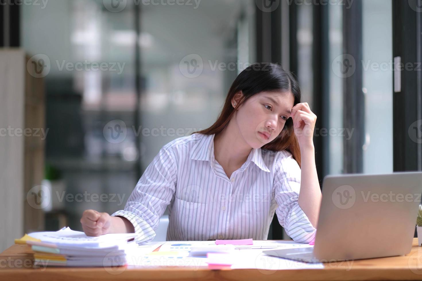 jovem empresária asiática sentindo dor de cabeça doente estressado cansado com papelada em cima da mesa. foto