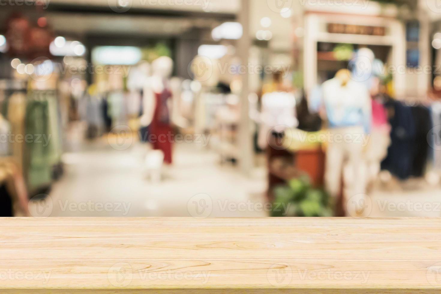 mesa de madeira vazia com vitrine de loja de roupas boutique de moda feminina em shopping foto
