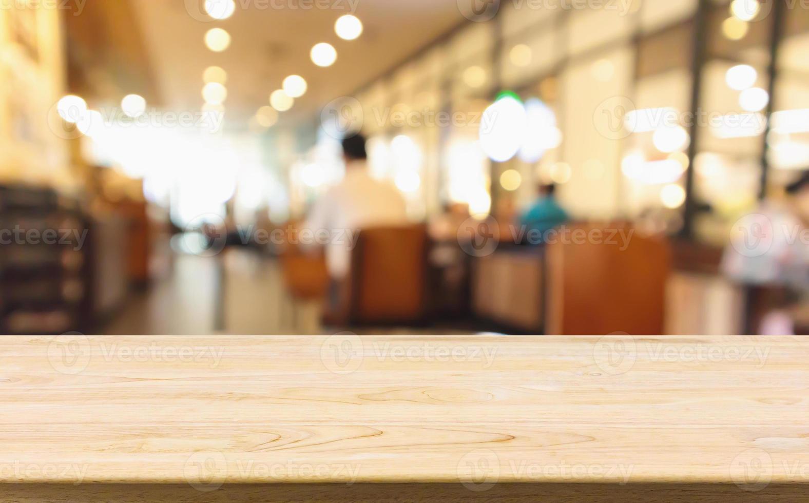 mesa de madeira com restaurante café ou café interior com pessoas abstratas desfocadas desfocar o fundo foto