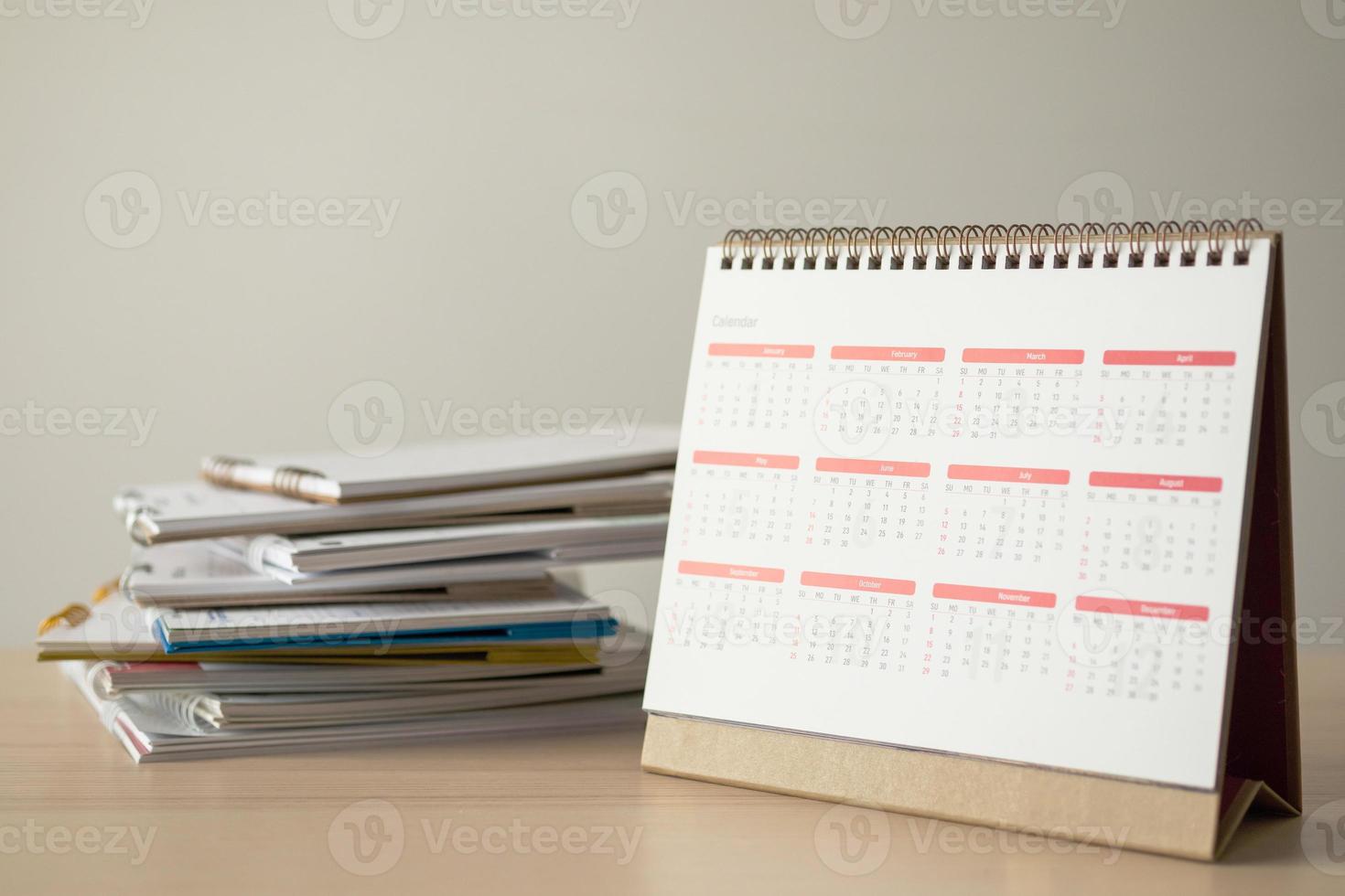 página do calendário fechar na mesa de madeira com fundo de parede branca conceito de reunião de planejamento de negócios foto