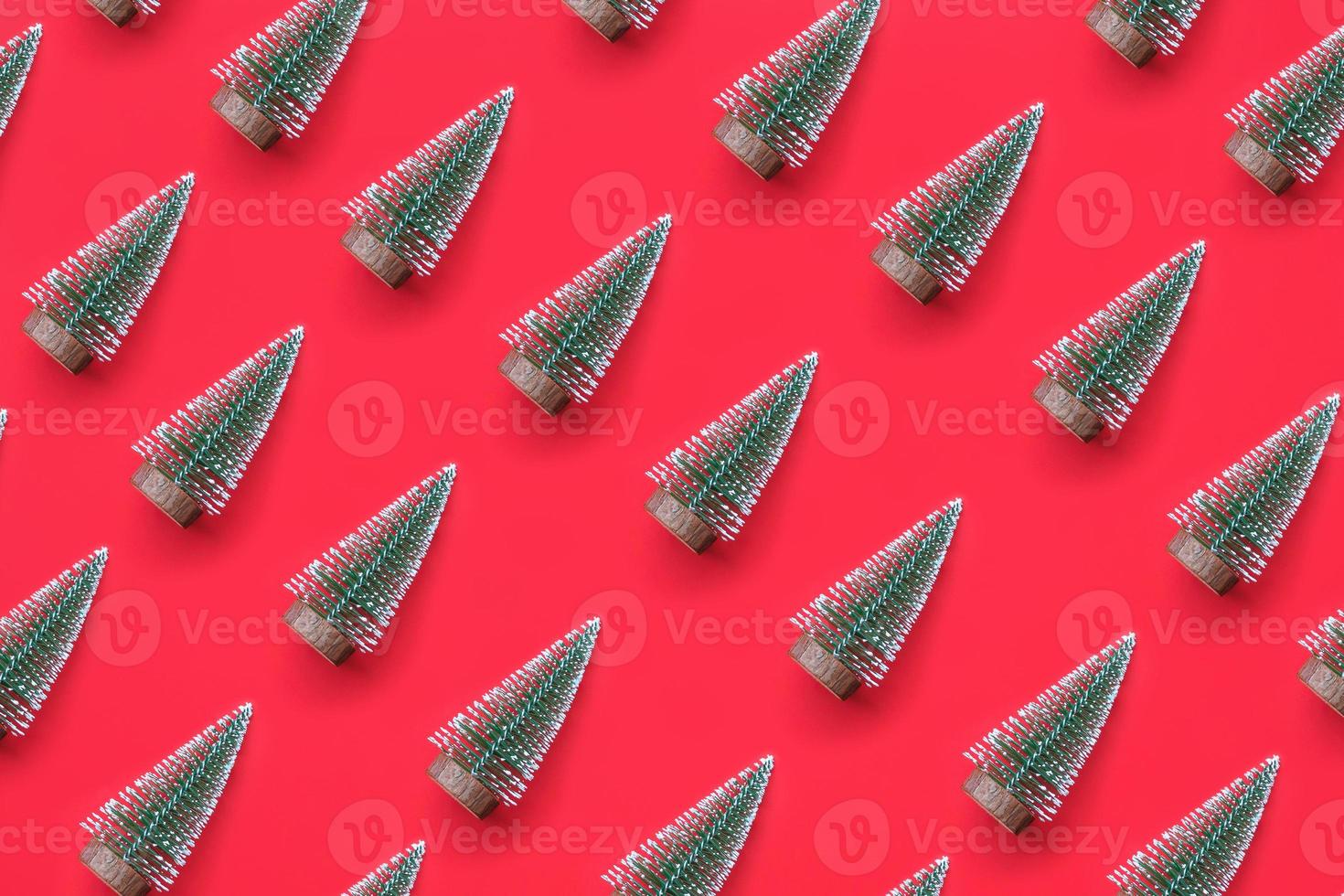 flatlay mínimo de padrão de árvore de natal verde no conceito de celebração de feriado de ano novo de fundo vermelho foto