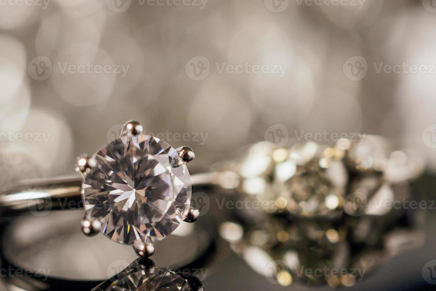 anéis de diamante de joias de luxo com reflexo no fundo preto foto