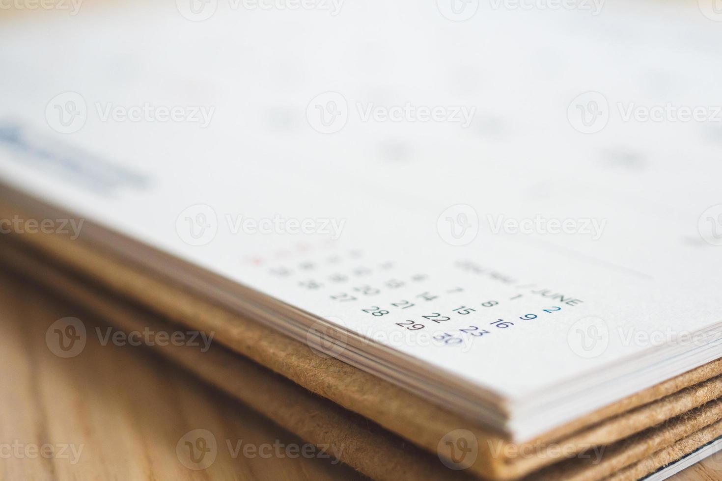 página de calendário no fundo da mesa de madeira foto