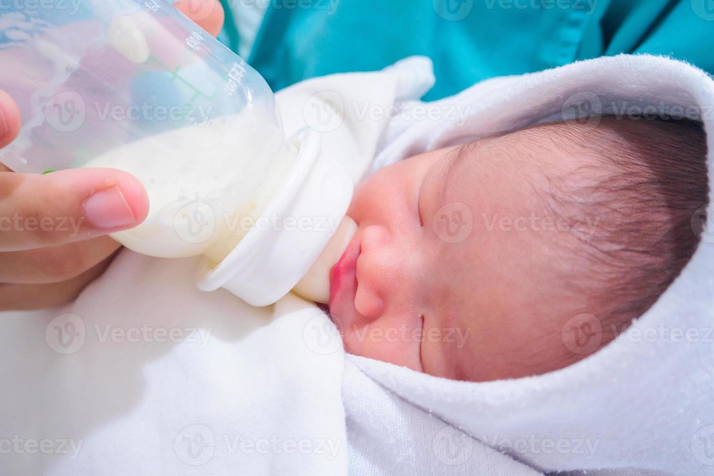 mãe alimentando bebê recém-nascido da garrafa foto