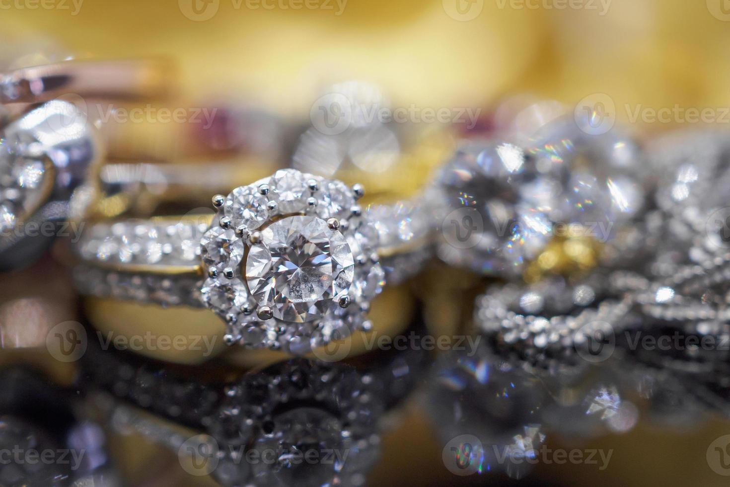 anéis de diamante de joias de ouro de luxo com reflexo no fundo preto foto