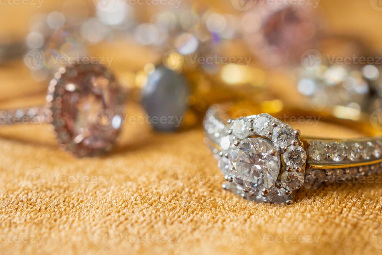 anéis de diamante de joias em fundo de tecido dourado close-up foto