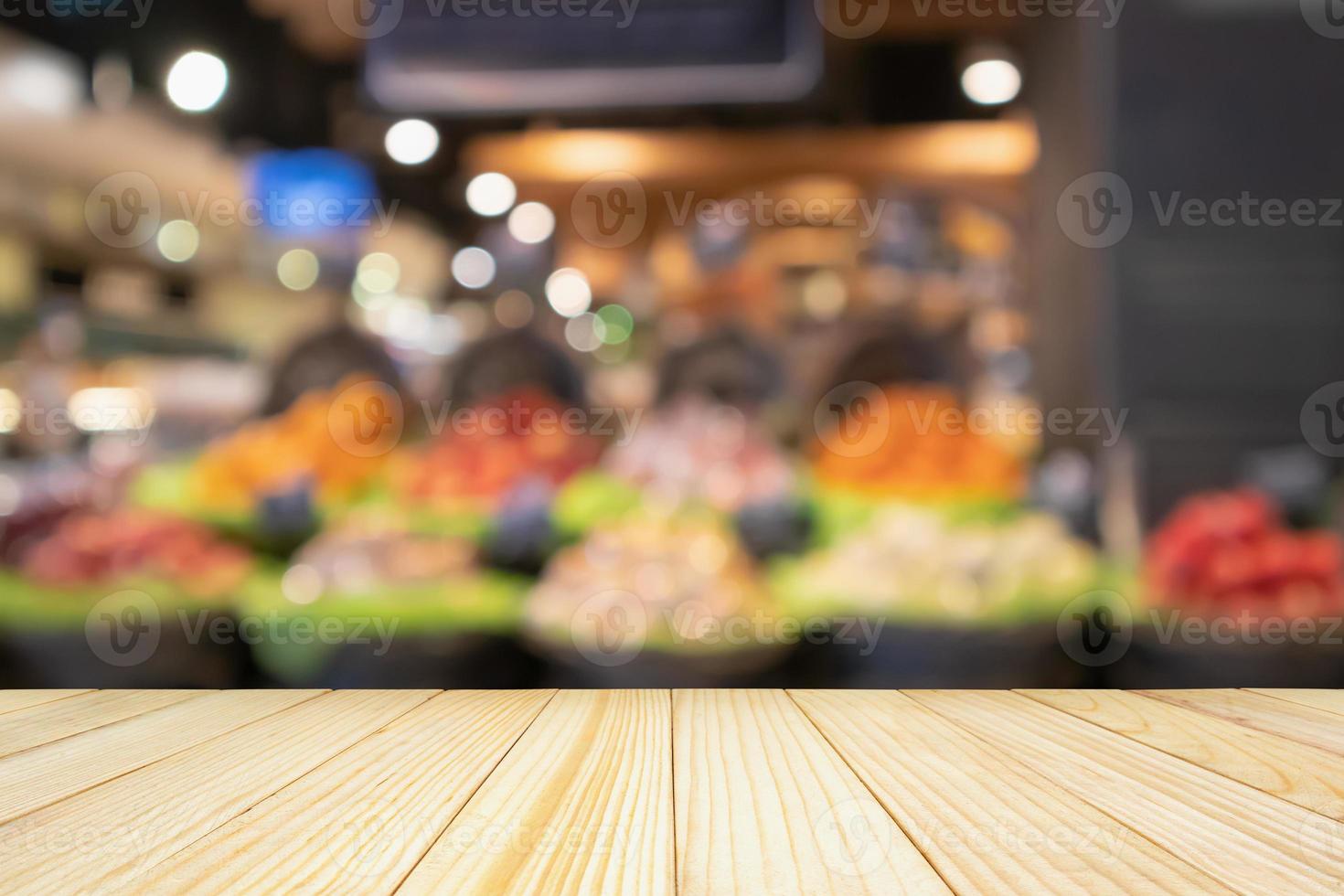tampo da mesa de madeira vazia com frutas coloridas desfocadas abstratas na cesta de exibição na mercearia de supermercado fundo desfocado com luz bokeh foto