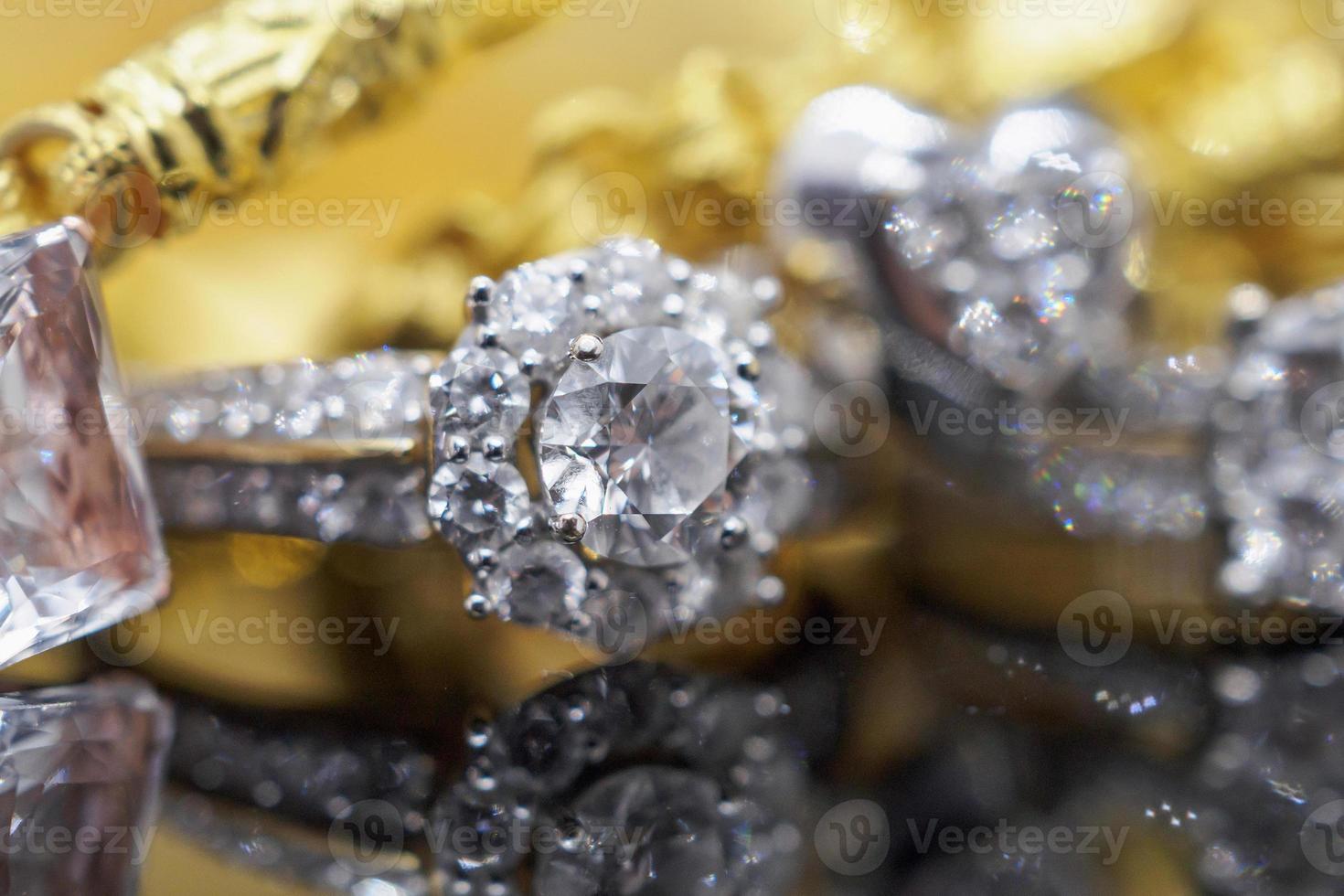 anéis de diamante de joias de ouro de luxo com reflexo no fundo preto foto