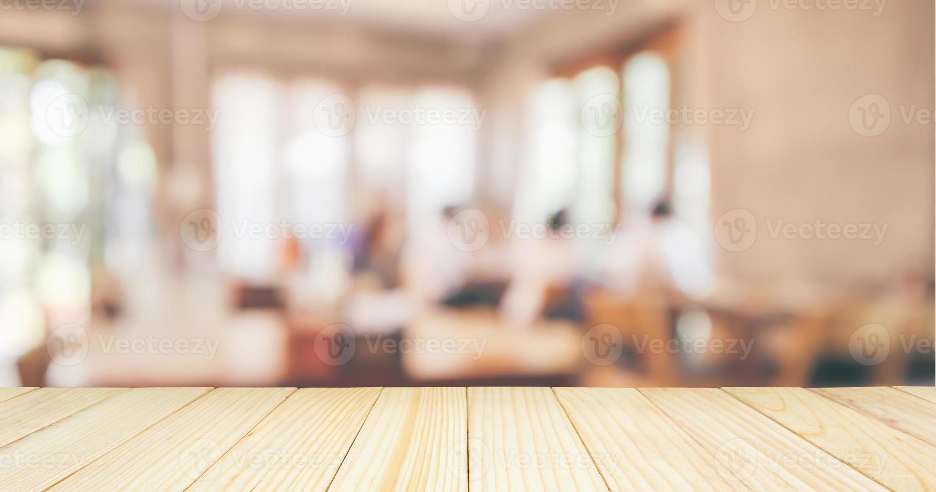 tampo da mesa de madeira com restaurante café ou interior de cafeteria com pessoas abstratas desfocadas desfocar o fundo foto