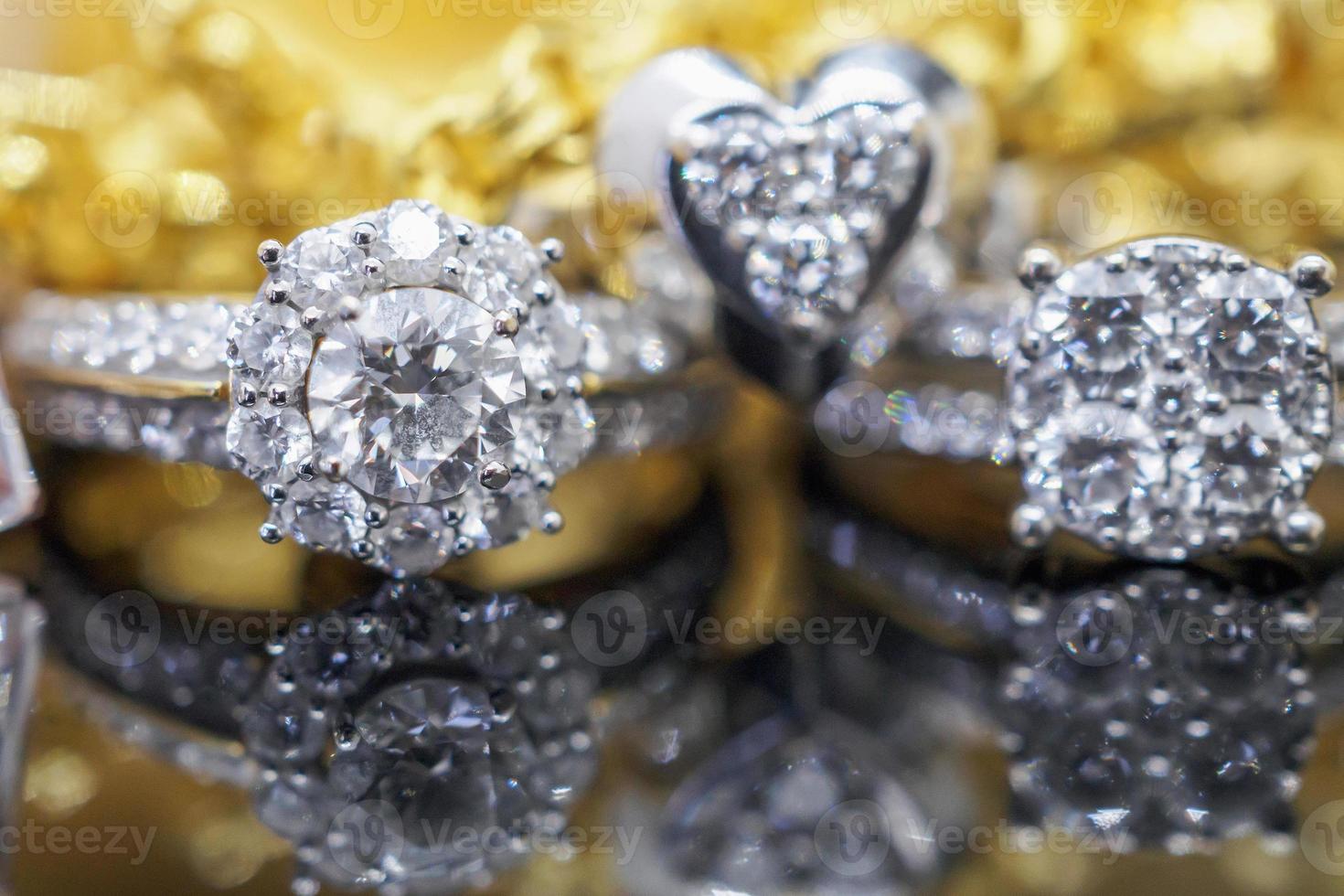 anéis de diamante de joias de ouro de luxo com reflexo no fundo preto foto