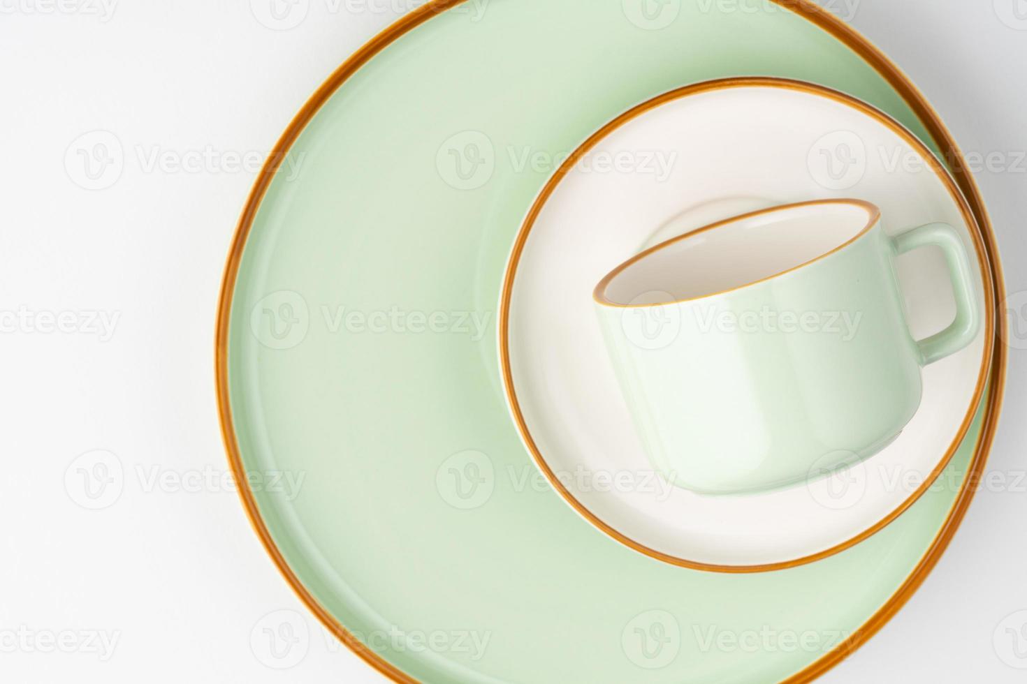 um conjunto de talheres de cerâmica verde pastel e branco com contornos laranja foto