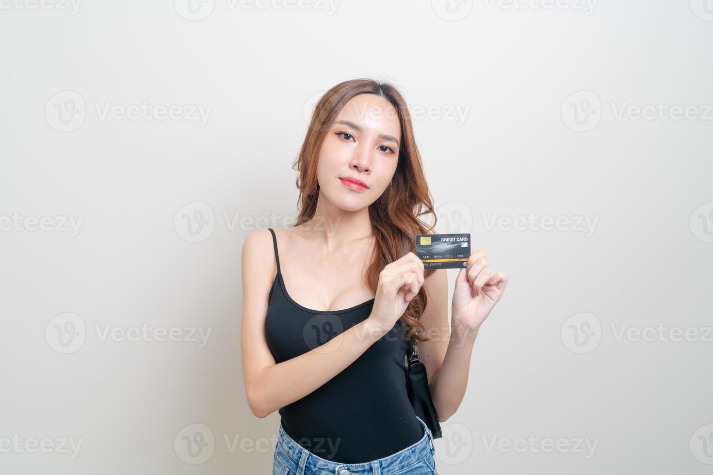 retrato linda mulher asiática segurando um cartão de crédito foto