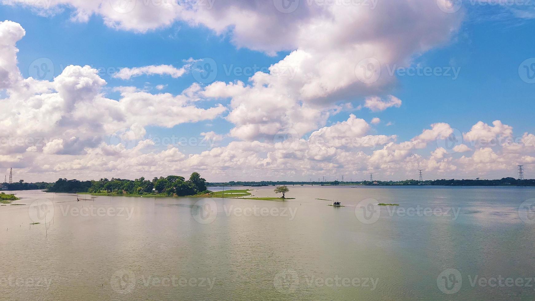 bela foto de um lago cercado por vegetação sob um céu nublado