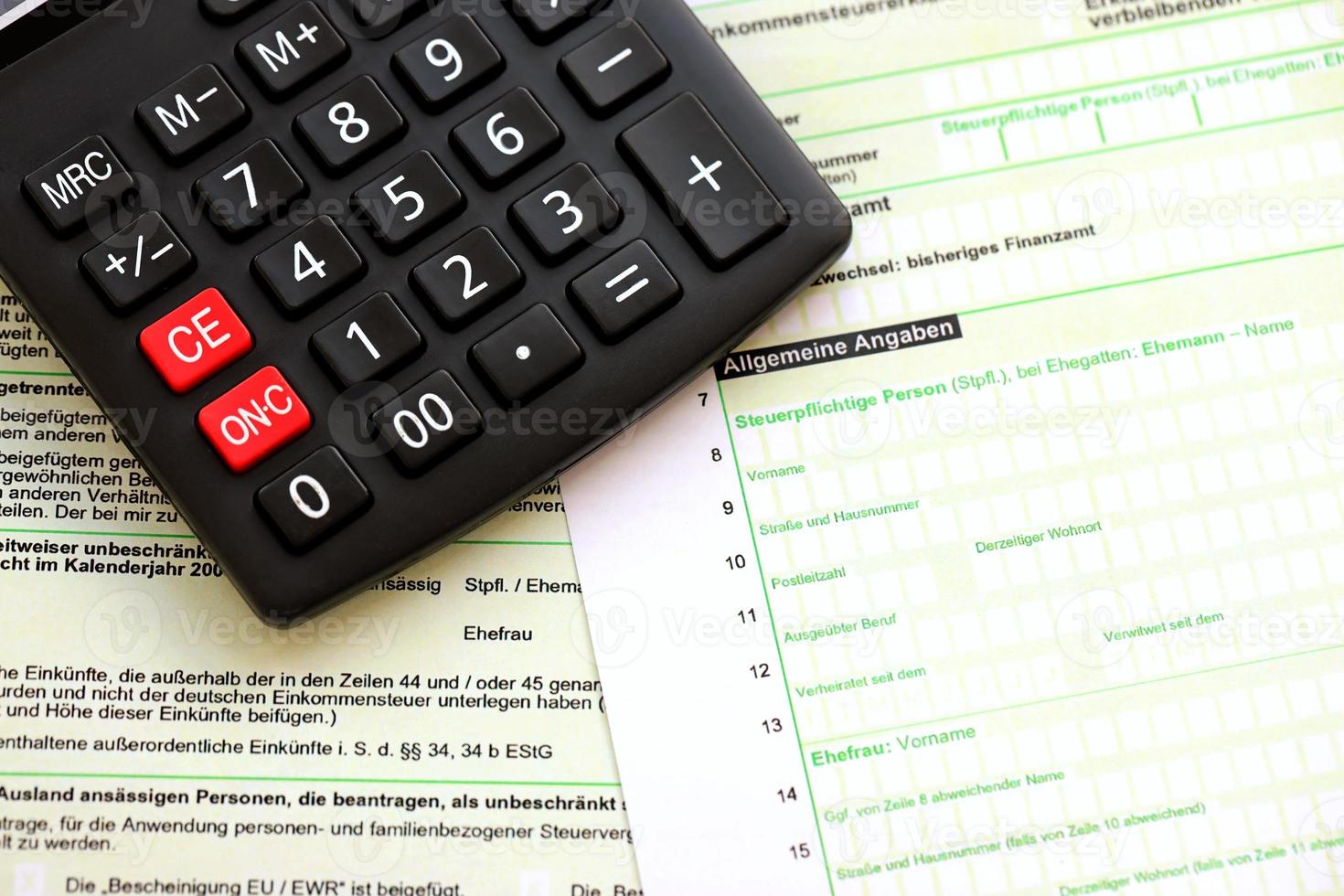 declaração de retorno de imposto de renda anual alemão e calculadora encontra-se na mesa do contador close-up. o conceito de período de pagamento de impostos na alemanha foto