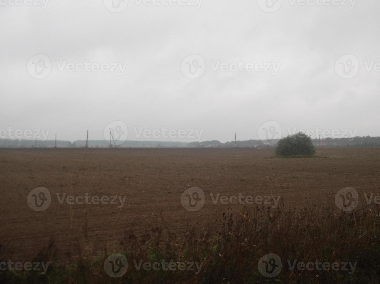 panorama de um campo arado na aldeia ao pôr do sol foto