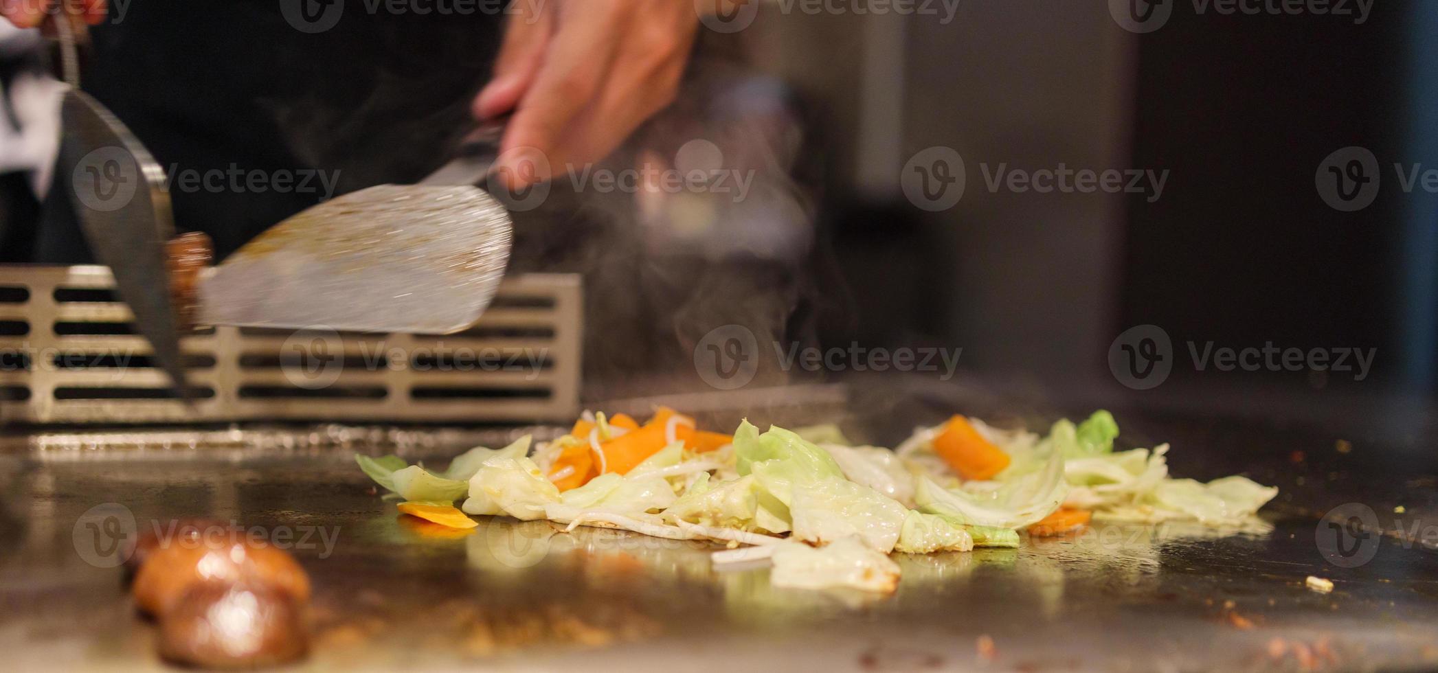 chef japonês cozinhando carne no restaurante teppanyaki foto