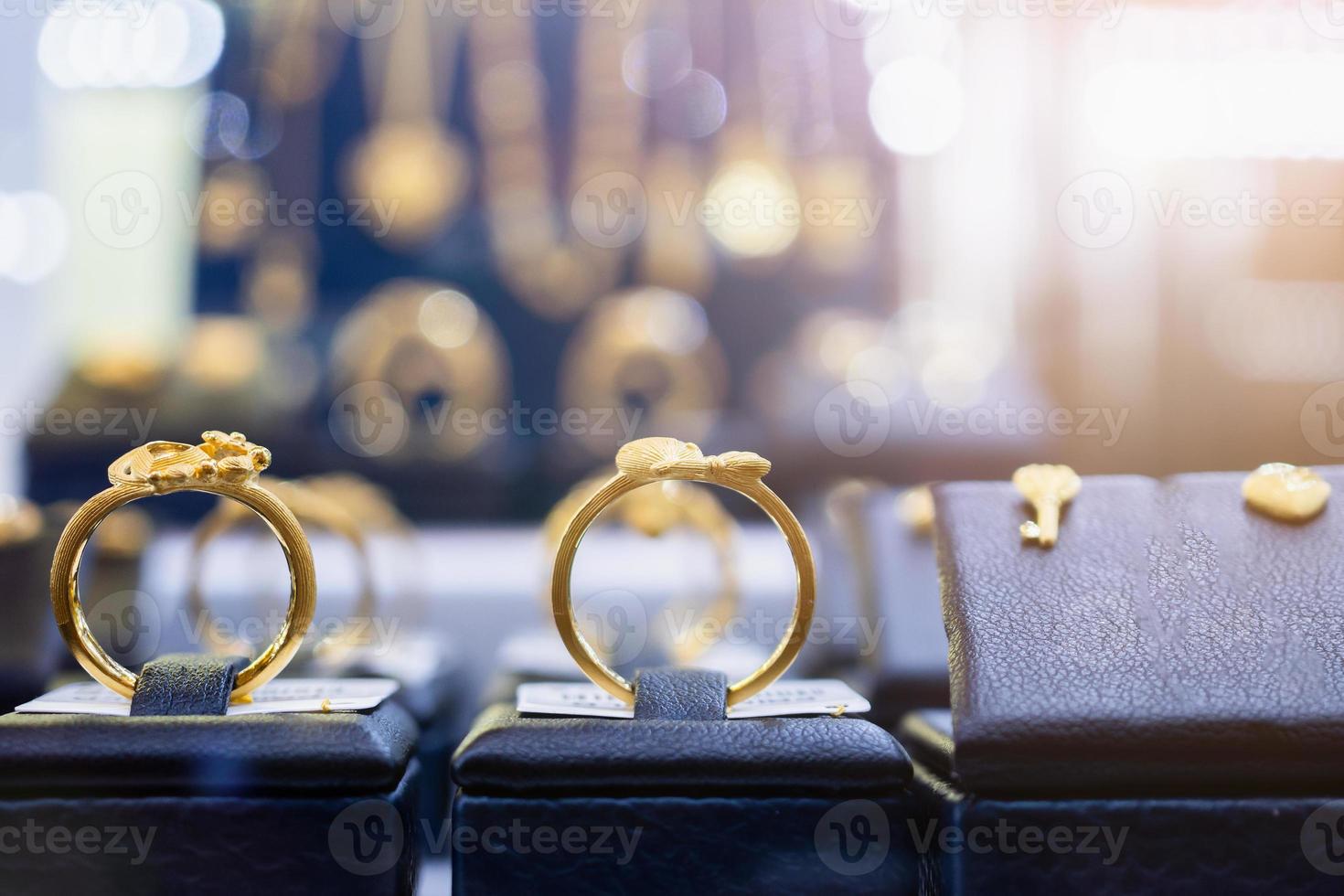 brincos e colares de anéis de ouro de joias são exibidos em vitrine de loja de varejo de luxo foto