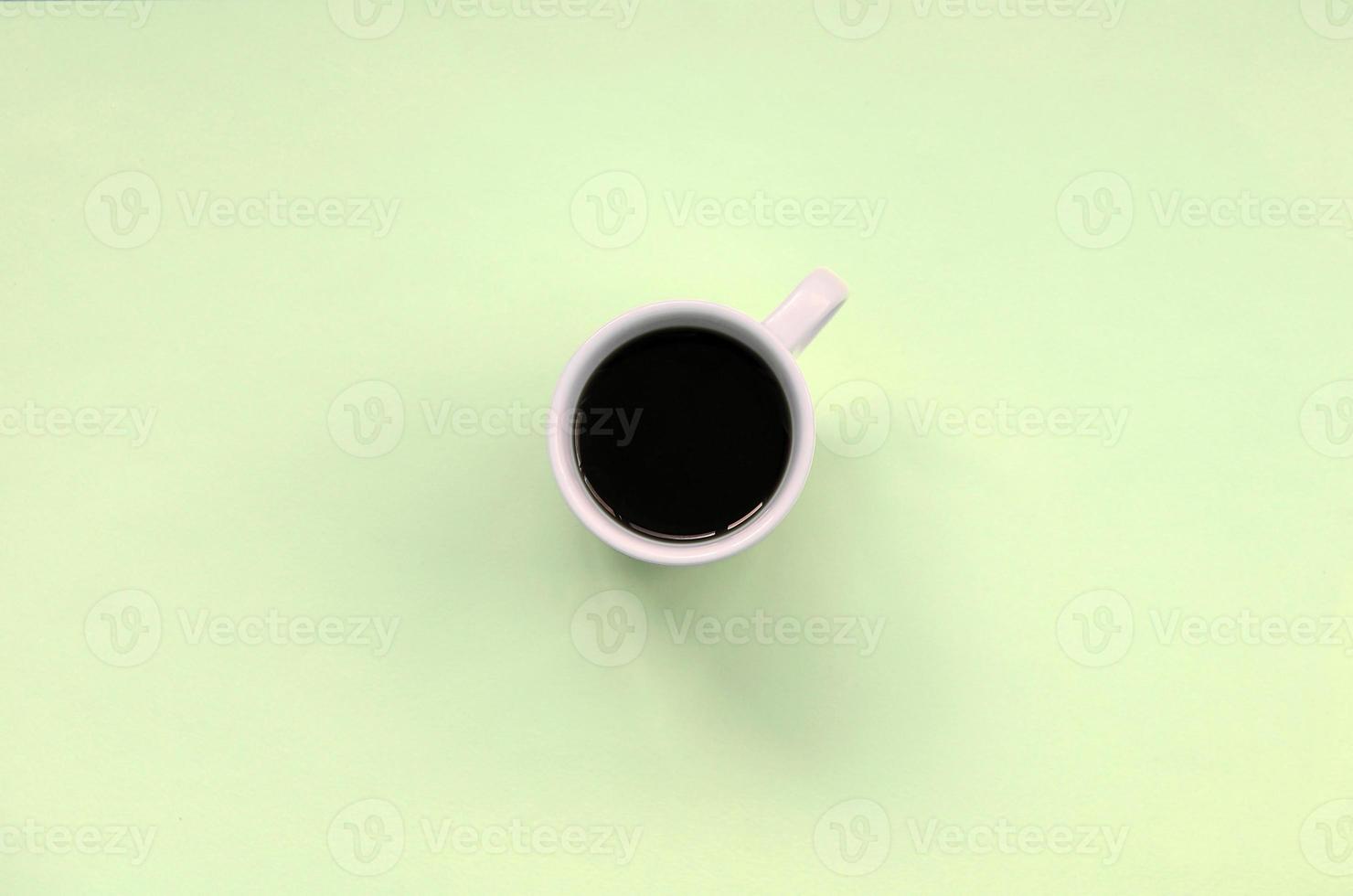 pequena xícara de café branco sobre fundo de textura de papel de cor de limão pastel de moda foto